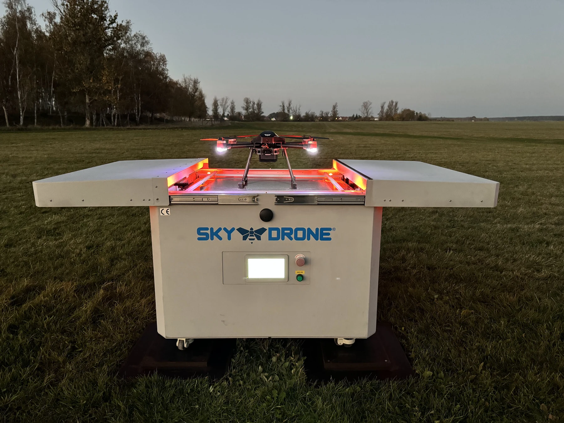 Sky-Drone-Drohne auf ihrer geöffneten Station im Freien, mit sichtbarem Markenlogo an der Station